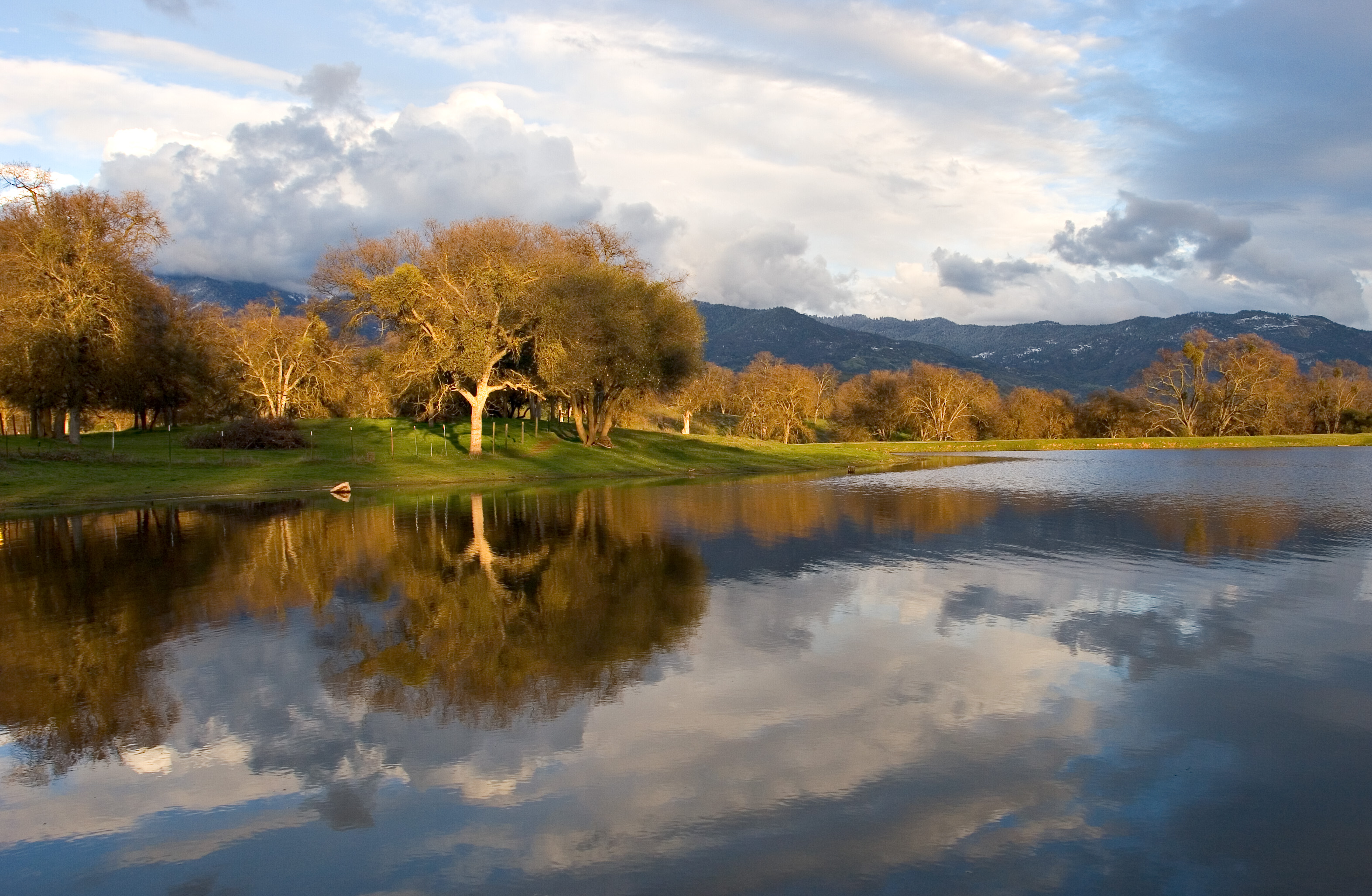 A view of the Sierra mountains with the pond at the Circle J-Norris Ranch in the foreground