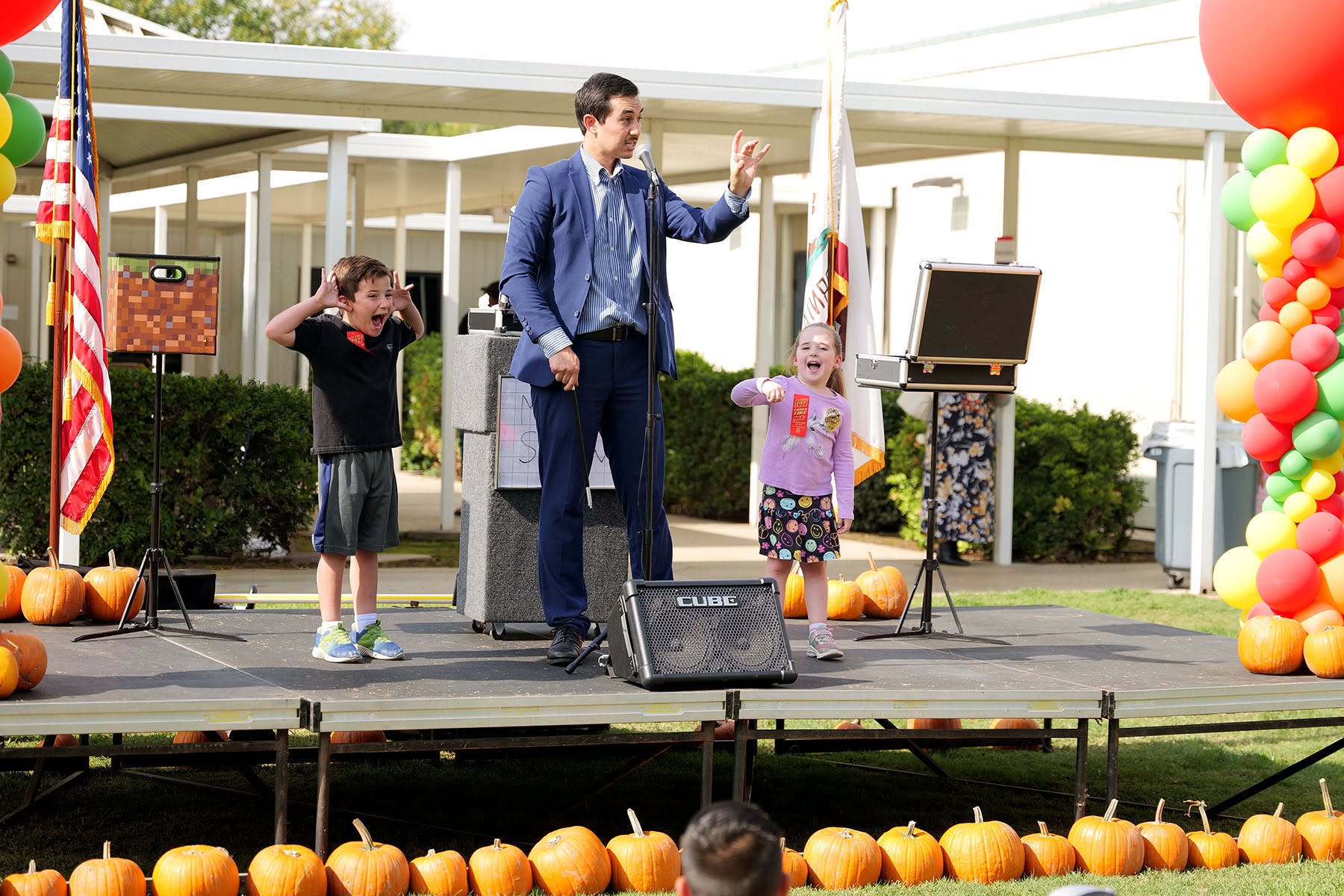 Magician with students on stage.