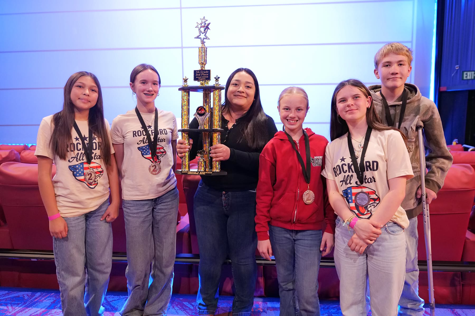 2 Students and teacher with trophy.