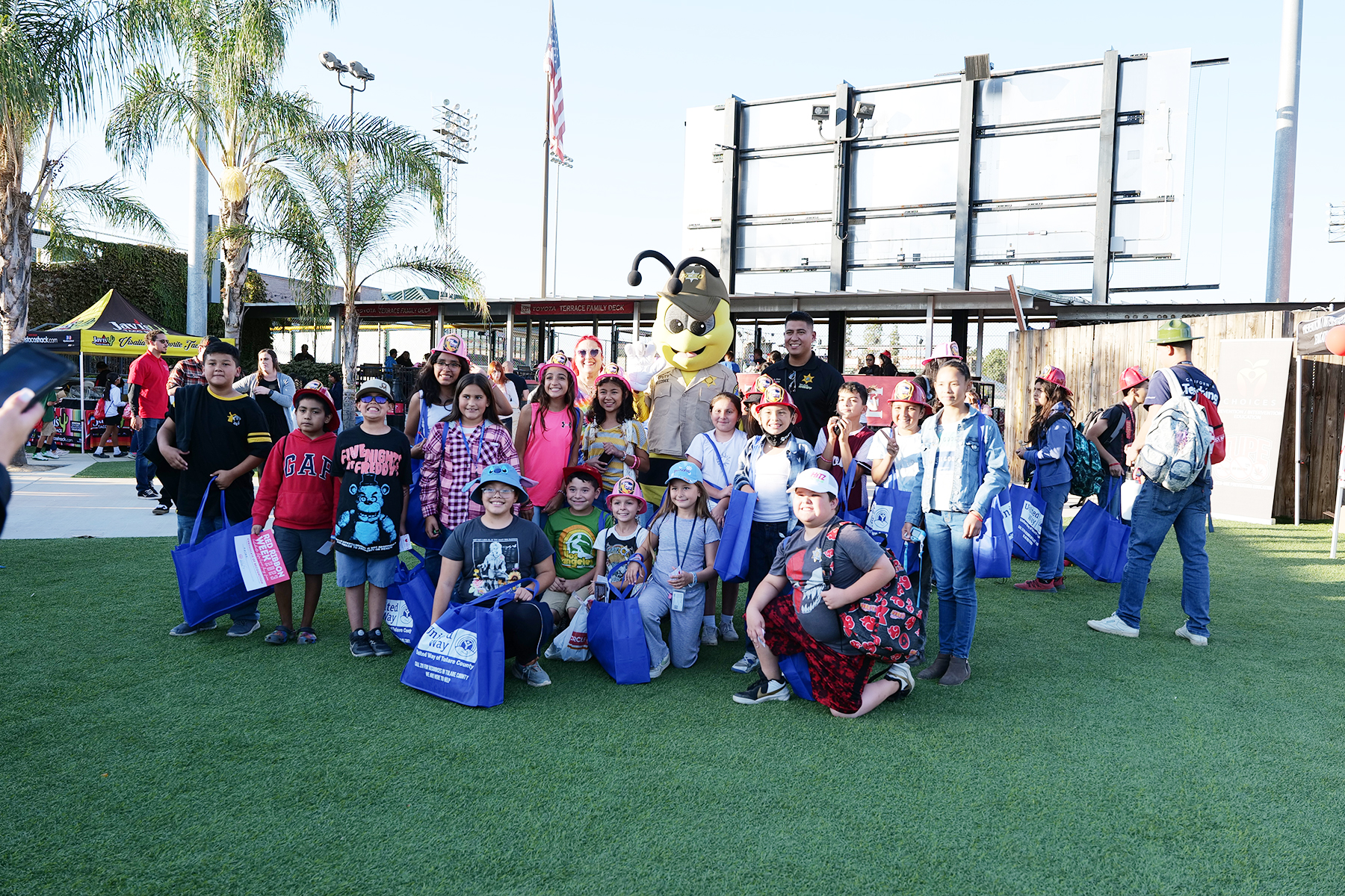 youth taking a photo with TCSO at Red Ribbon week event at Rawhide stadium