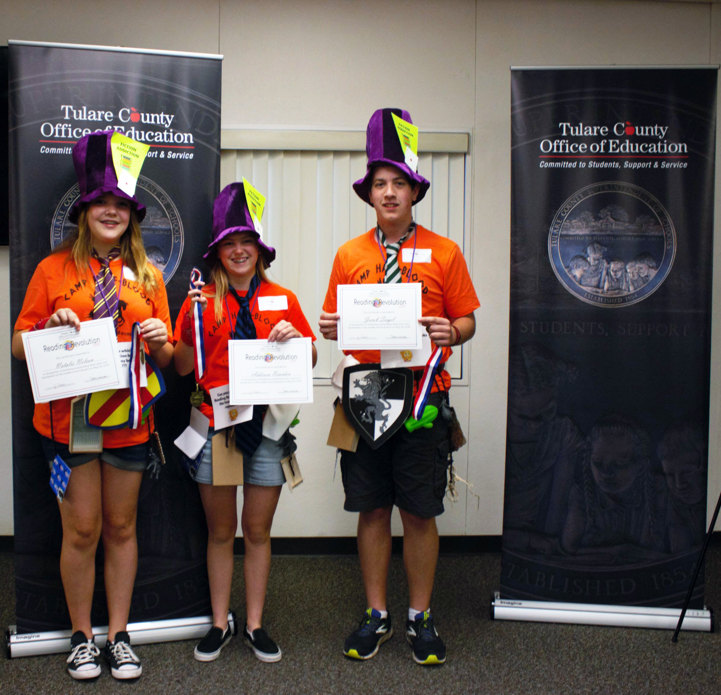 Reading Revolution students holding up their certificates and medals