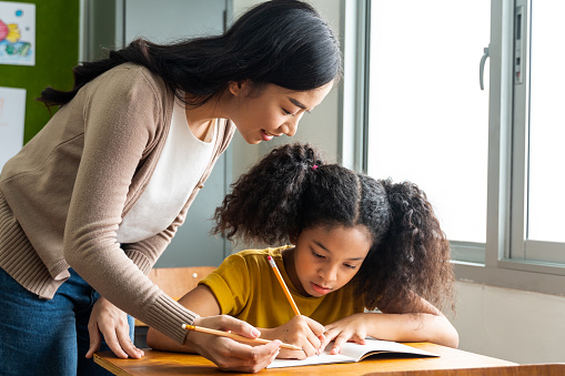 This photo shows a female teacher working with a female student.